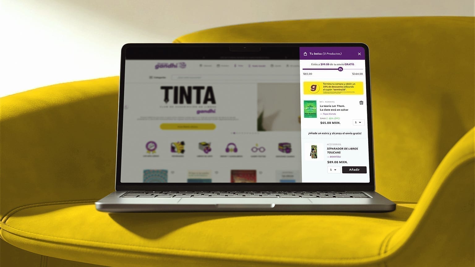 Librerías Gandhi homepage on a laptop with the Tu Bolsa cart drawer open, on a yellow armchair.