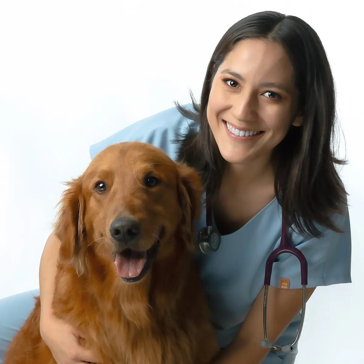 Veterinarian Cynthia hugging a golden retriever.