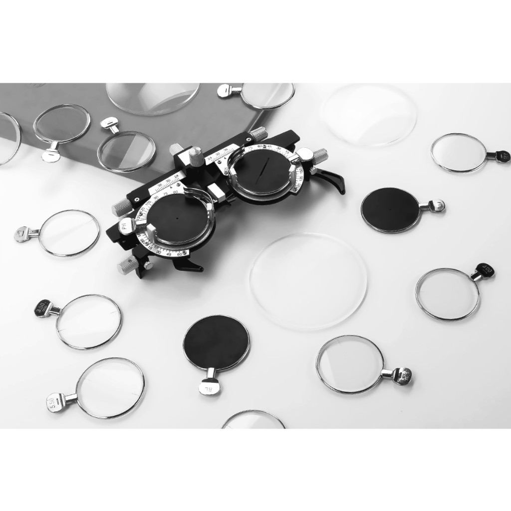 Monochrome top-down trial frame, labeled trial lenses, and a large rimless demo lens near center—no people. Arthur & Sons Mexico collection — photograph 116 of 119.