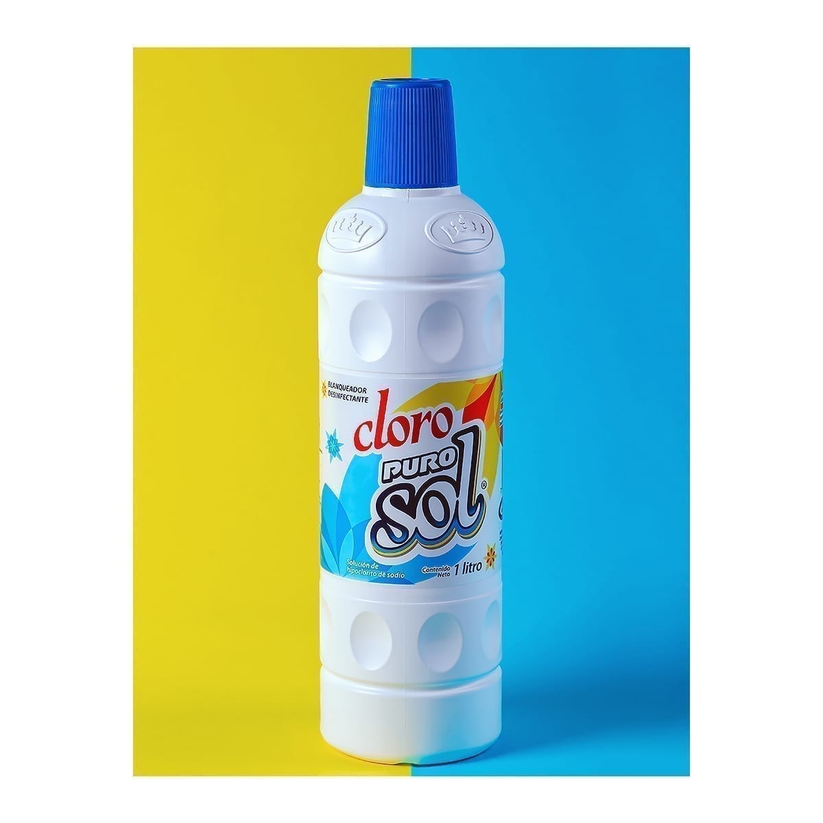 1 L Cloro Puro Sol bleach disinfectant bottle; split yellow and blue backdrop. “100 Years of History” editorial project, Fábrica de Jabón La Corona — piece 16 of 38.