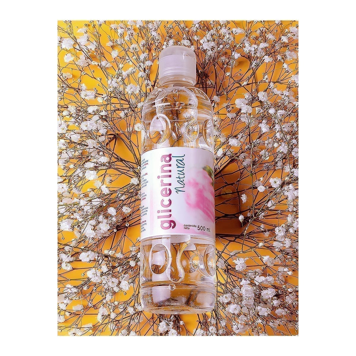 Upright 500 ml Natural Glycerin bottle on baby’s breath and yellow. “100 Years of History” editorial project, Fábrica de Jabón La Corona — piece 20 of 38.