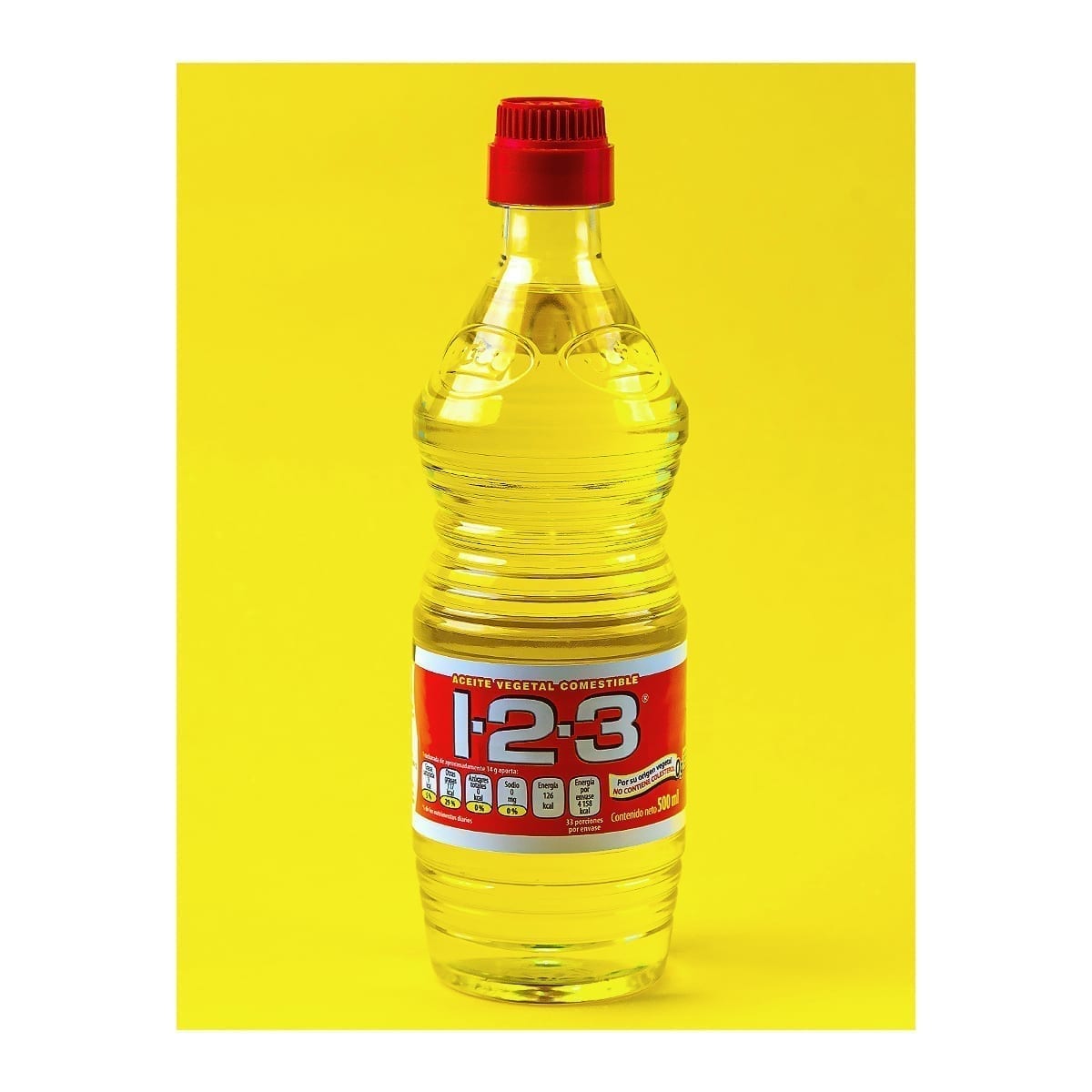 500 ml 1-2-3 vegetable oil bottle on solid yellow. “100 Years of History” editorial project, Fábrica de Jabón La Corona — piece 21 of 38.