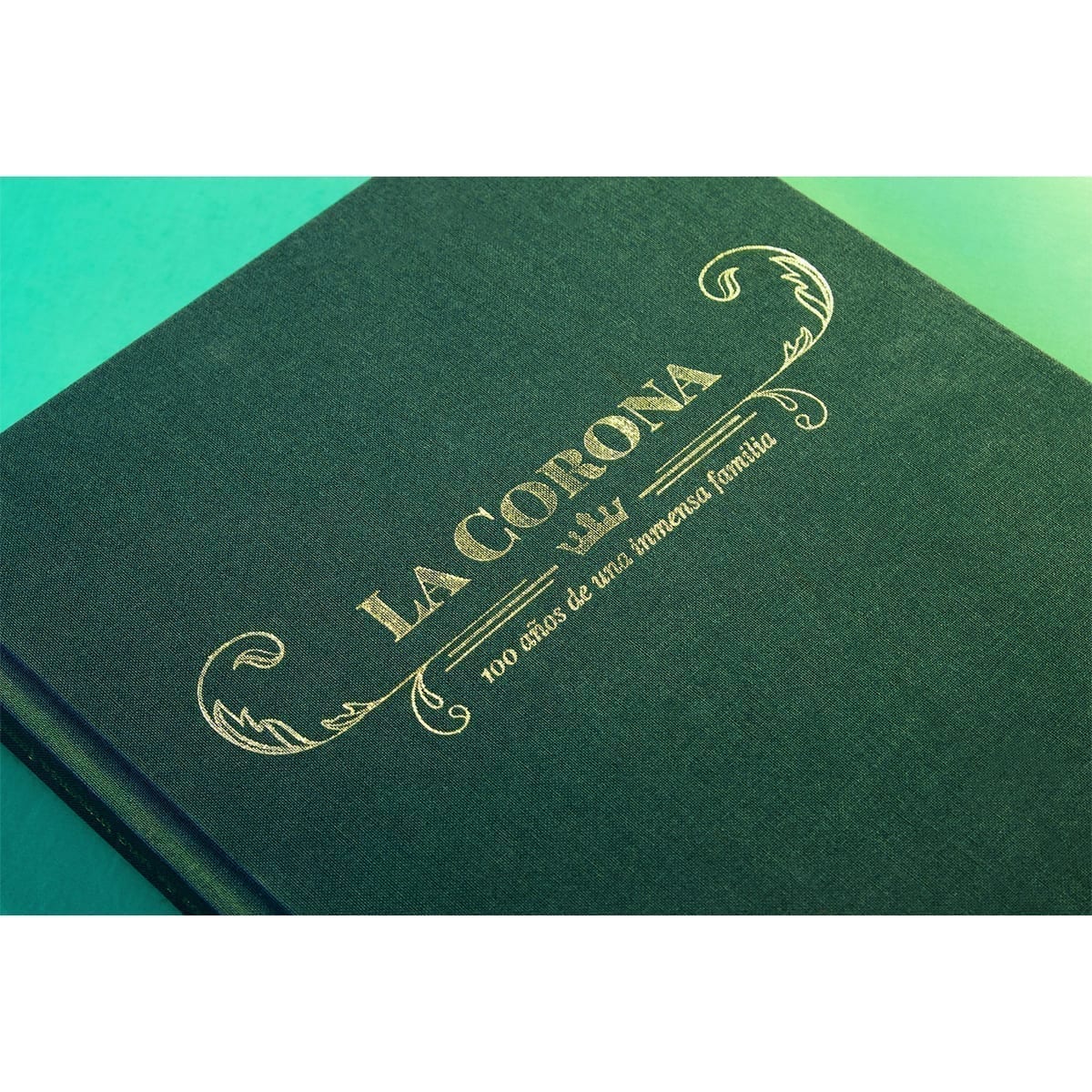 Angled commemorative cover: green gradient, gold foil, and linen texture. “100 Years of History” editorial project, Fábrica de Jabón La Corona — piece 28 of 38.