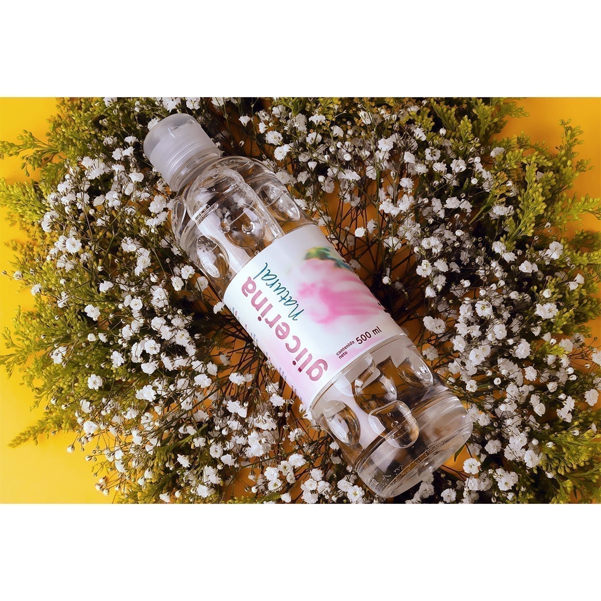 500 ml Natural Glycerin bottle on the diagonal over baby’s breath on yellow; pink type and blue script. “100 Years of History” editorial project, Fábrica de Jabón La Corona — piece 3 of 38.