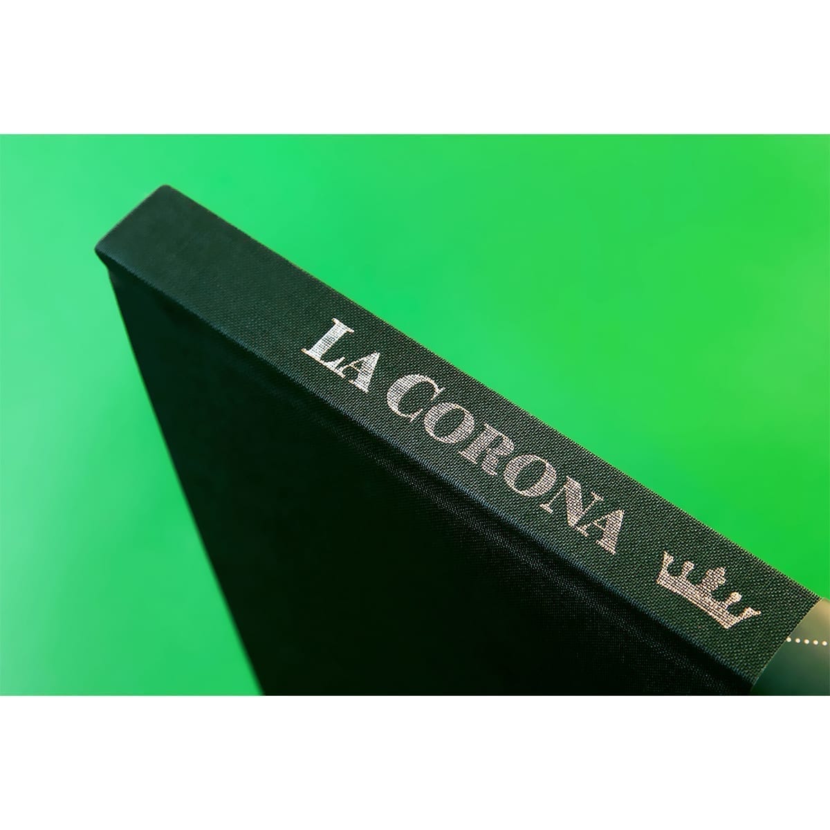 Black cloth spine with silver LA CORONA type and crown on neon green. “100 Years of History” editorial project, Fábrica de Jabón La Corona — piece 35 of 38.