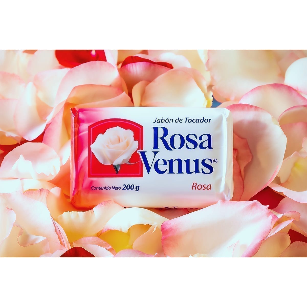 Wrapped Rosa Venus toilet soap bar (200 g) on soft pink and cream rose petals. “100 Years of History” editorial project, Fábrica de Jabón La Corona — piece 4 of 38.