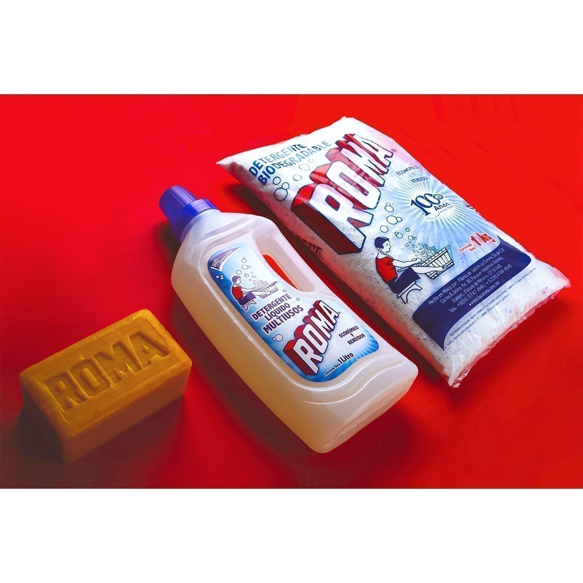 Roma lineup: laundry bar, 1 L multipurpose liquid detergent, and 1 kg powder detergent bag on red. “100 Years of History” editorial project, Fábrica de Jabón La Corona — piece 6 of 38.