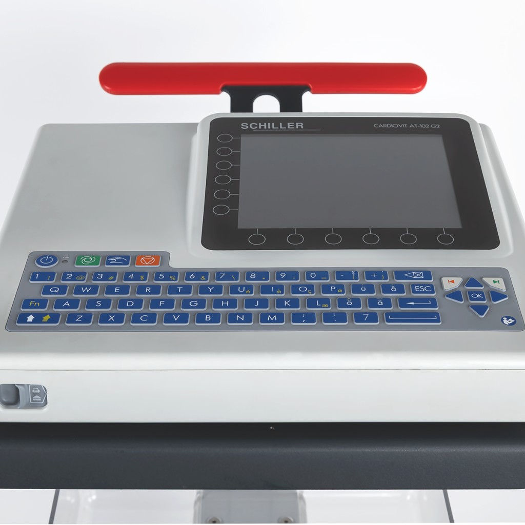 Cardiovit AT-102 G2 with red carry handle, screen and keyboard; close-up on dark cart shelf — Schiller resting ECG.